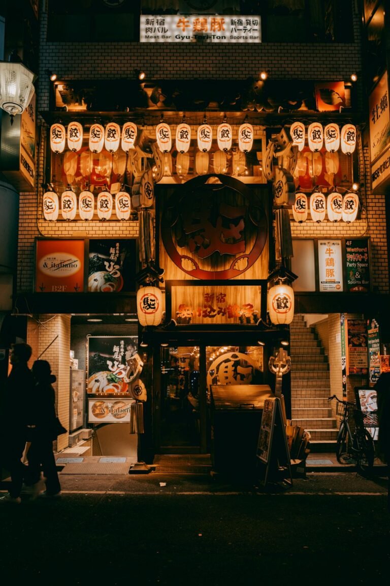A vibrant izakaya adorned with lanterns in Tokyo's nightlife district, captured at night.